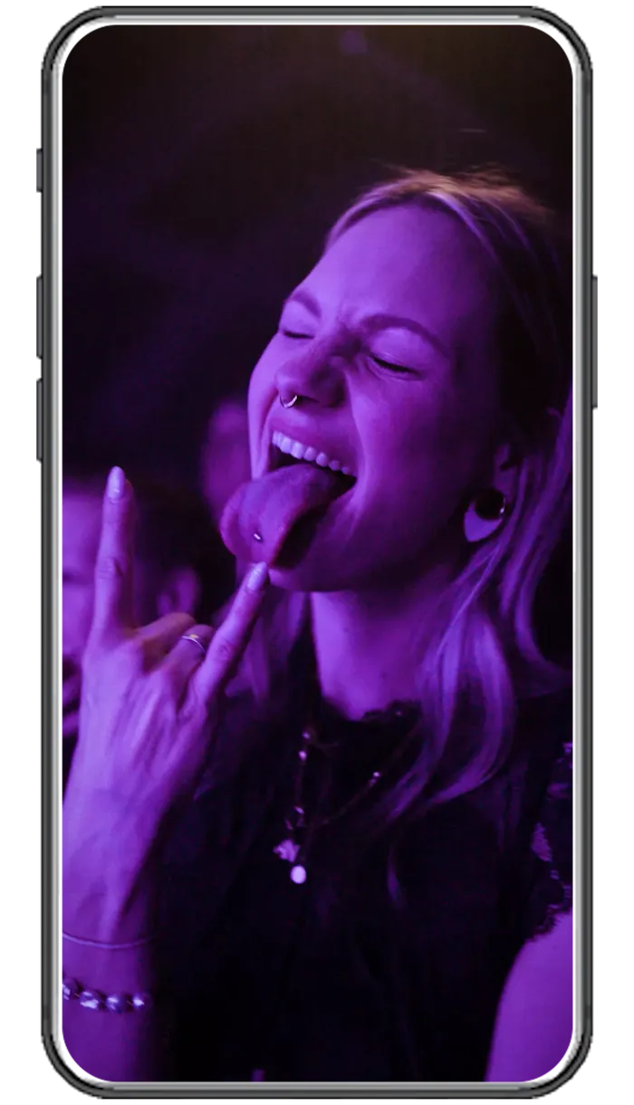 High-Energy Social-Media-Reel-Produktion für Live-Events und Musikkonzerte; authentische Momentaufnahme einer Konzertbesucherin in lila Bühnenlicht.